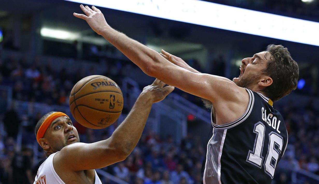 Ekspresi pemain San Antonio Spurs, Pau Gasol (kanan) saat berebut bola dengan pemain Phoenix Suns, Jared Dudley pada laga NBA di Talking Stick Resort Arena, (15/12/2016). Spurs menang 107-92. (AP/Ross D. Franklin)