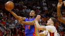 Pemain Detroit Pistons Ish Smith (kiri) melakukan tembakan melewati hadangan pemain Miami Heat, Tyler Johnson (kanan) pada laga NBA di American Airlines Arena, Miami, (01/01/2017). Pistons menang 107-98. (AP/Joe Skipper)