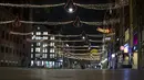 Jalan Damrak yang sepi terlihat selama jam malam di jantung kota Amsterdam, Sabtu (23/1/2021). Belanda memasuki fase terberat dari pembatasan anti-virus Corona hingga saat ini. (AP Photo/ Peter Dejong)