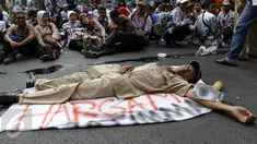 Seorang guru terlihat tidur di tengah jalan karena lelah usai melakukan unjuk rasa di depan Gedung DPR/MPR, Jakarta, Selasa (15/9/2015). Ribuan guru honorer melakukan aksi demo menuntut perubahan status honorer K2 menjadi PNS. (Liputan6.com/Yoppy Renato)
