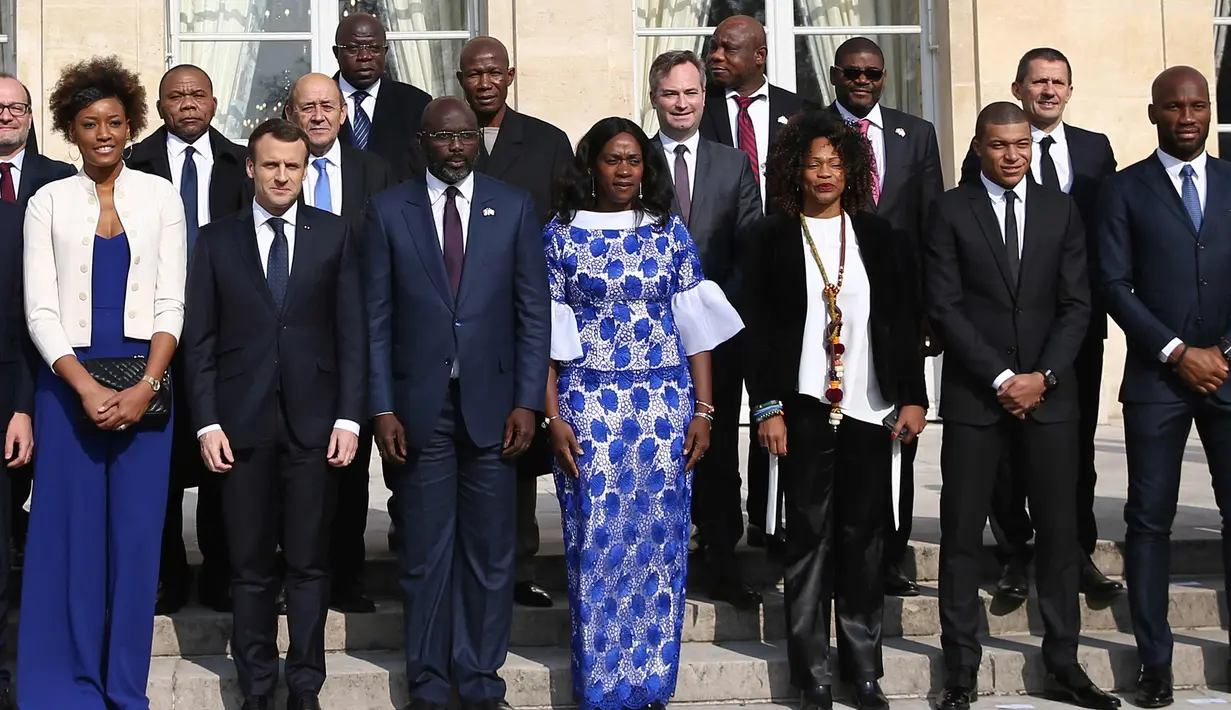 Didier Drogba (kanan) foto bersama dengan Presiden Liberia George Weah (depan ketiga kiri) dan Presiden Prancis Emmanuel Macron (depan kedua kiri) sebelum makan siang di Istana Elysee di Paris, (21/2). (AFP Photo/Ludovic Marin)