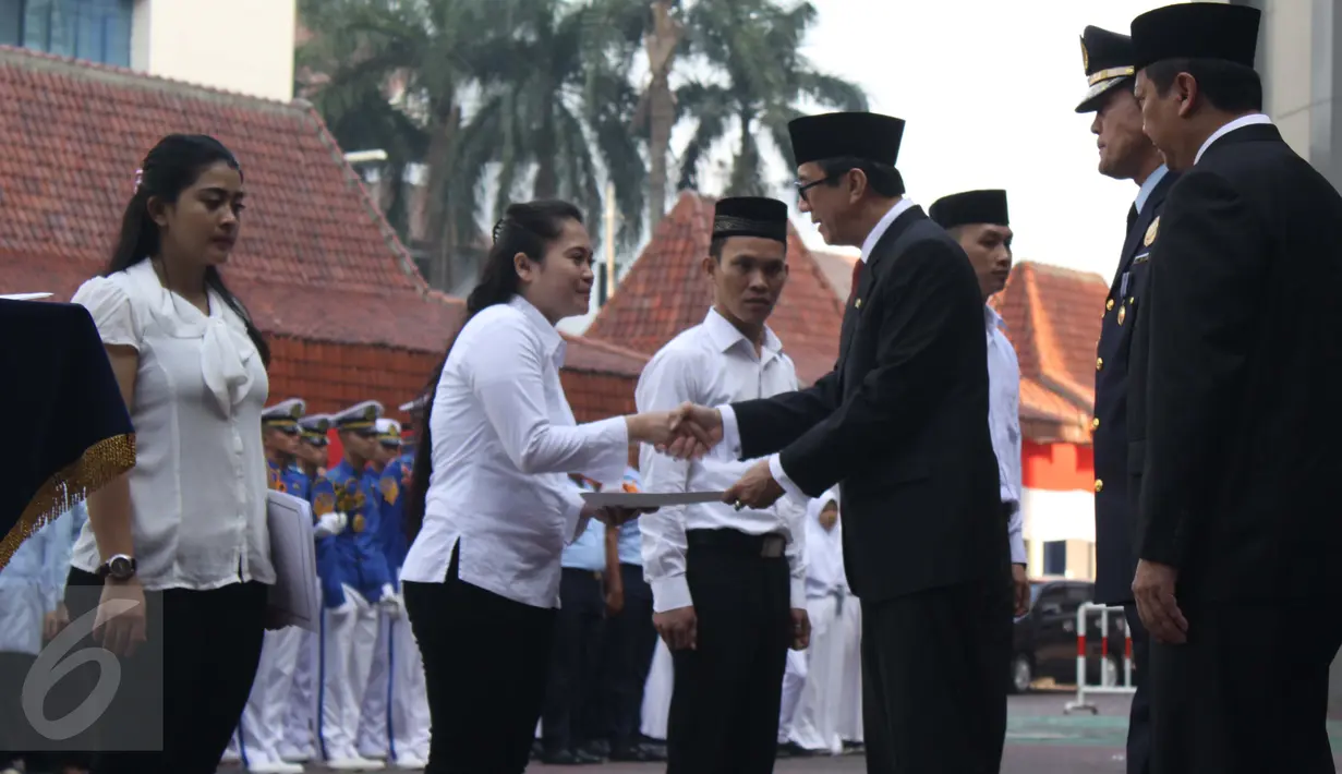 Menkumham Yasonna Laoly (tengah) saat secara simbolis memberikan remisi kepada empat orang narapidana di kantor Kemenkumham, Senin (17/8/2015). Sebanyak 1.938 orang narapidana korupsi mendapatkan remisi pada HUT RI ke-70. (Liputan6.com/Gempur M Surya)