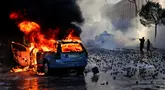 Sebuah mobil terbakar saat bentrokan pecah dalam aksi demonstrasi antipemerintah di luar kantor Perdana Menteri di Tirana, Albania, Sabtu (17/10/2026). (AP Photo/Hameraldi Agolli)