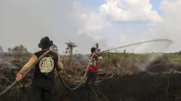 Petugas pemadam kebakaran  memadamkan kebakaran hutan pada lahan gambut seluas lebih dari 100 hektar) di Pulang Pisau, Provinsi Kalimantan Tengah, Indonesia, Jumat, 31 Juli 2026.  (AFP/ Reina)