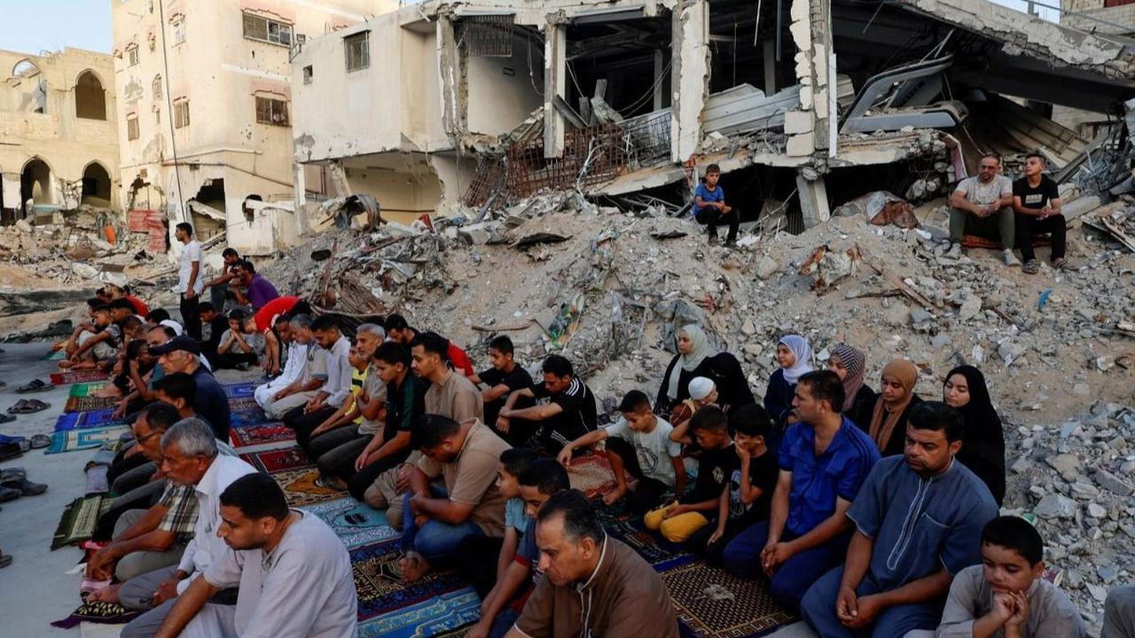 Warga Palestina di Khan Younis, Gaza pada hari Minggu (16/6/2024) mengadakan salat Iduladha di tengah reruntuhan Masjid Al-Rahma dan bangunan lainnya yang telah dihancurkan oleh serangan udara Israel. Foto: REUTERS / Mohammed Salem<br>