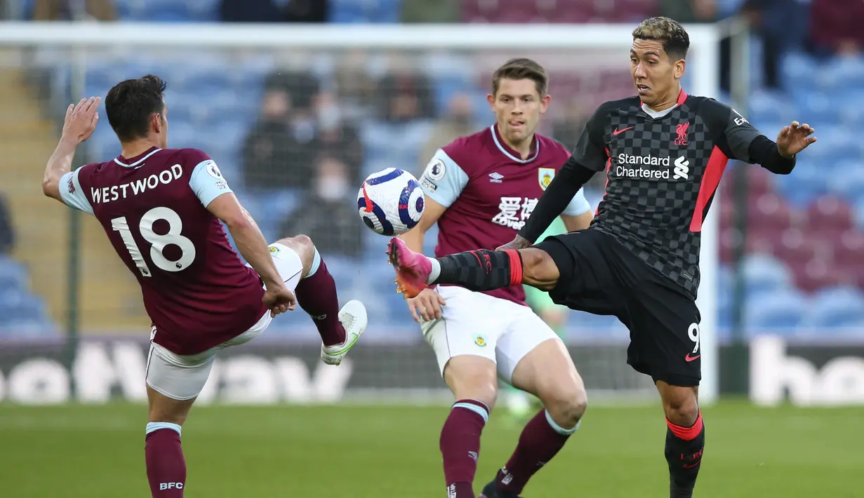 Penyerang Liverpool, Roberto Firmino ditantang oleh gelandang Burnley, Ashley Westwood pada pekan ke-37 Liga Inggris di Stadion Turf Moor, Kamis (20/5/2021) dini hari WIB. Liverpool sukses menembus empat besar klasemen Liga Inggris setelah menang telak 3-0 atas Burnley. (Alex Livesey/Pool via AP)