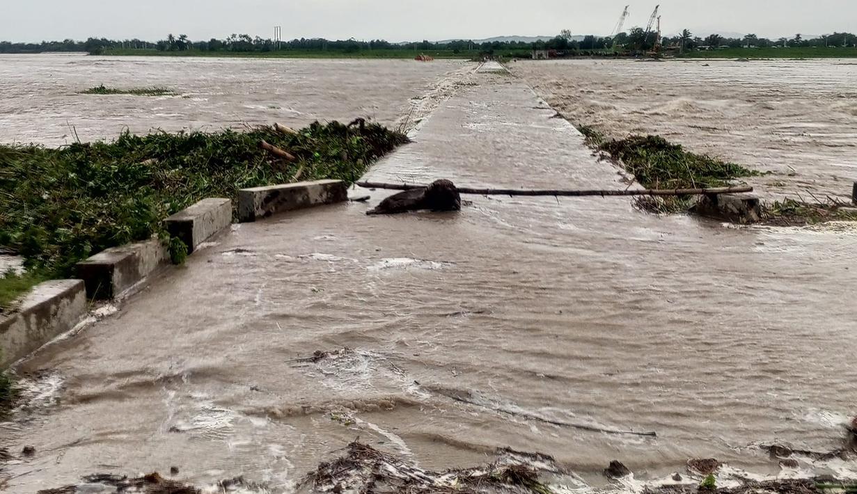 Foto selebaran yang diambil pada 26 Juli 2023 dan diterima melalui halaman Facebook kantor informasi provinsi Cagayan ini menunjukkan jembatan yang terendam banjir di kota Tuao, provinsi Cagayan, Filipina setelah sebuah sungai meluap akibat hujan lebat yang disebabkan oleh Topan Super Doksuri. (STRINGER/Cagayan provincial information office/AFP)
