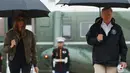 Presiden AS, Donald Trump dan Ibu Negara Melania Trump berjalan menuju pesawat kepresidenan di Pangkalan AU Andrews, Maryland, Selasa (29/8). Trump akan melakukan perjalanan ke Texas guna meninjau lokasi pasca Badai Harvey. (AP Photo/Evan Vucci)