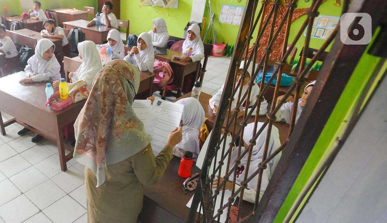 Siswa mengikuti ujian penilaian akhir semester (PAS) yang dihadiri guru pengawas di SDN Pondok Cina 1 Depok, Jawa Barat, Senin (5/12/2022). Ujian akhir tersebut dilakukan seluruh siswa baik dari kelas 1 hingga kelas 6 SD. (merdeka.com/Arie Basuki)