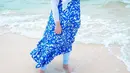 Dress penuh motif warna cerah seperti Tasyi Athasyia, jadi pilihan menarik untuk OOTD ke pantai.