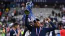 Penyerang PSG, Kylian Mbappe, merayakan trofi juara Piala Prancis usai mengalahkan Saint-Etienne pada pertandingan final di Stadion Stade de France, Sabtu (25/7/2020) dini hari WIB. PSG menang 1-0 atas Saint-Etienne. (AFP/Franck Fife)