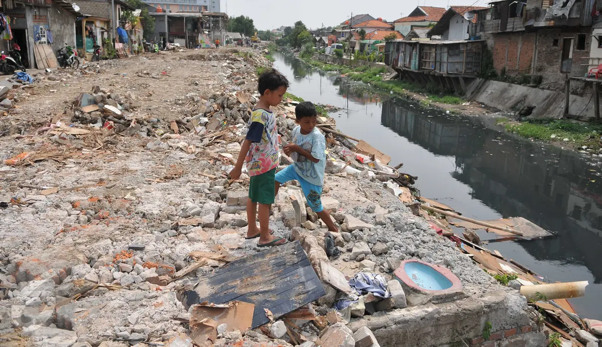 Dua anak bermain di sisa gusuran bangunan di Kali Sekretaris, Kampung Rawa, Jakarta, Selasa (17/11). Warga menyesalkan sikap Gubernur Ahok yang pernah menjanjikan tidak akan ada penggusuran sebelum mendapat kunci rumah susun. (Liputan6.com/Gempur M Surya)