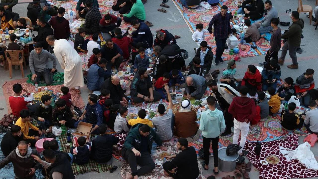Keluarga Palestina berbuka puasa bersama dengan berbagi makanan yang mereka bawa dari rumah di Kota Gaza pada 8 April 2023.