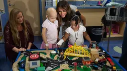 Ibu Negara AS, Melania Trump bermain dengan pasien anak, Essence dan Natalayah saat mengunjungi Rumah Sakit Anak Monroe Carell Jr. di Nashville, Selasa (24/7). Kedatangan Melania untuk berdiskusi terkait Neonatal Abstinence Syndrome (NAS). (AFP/SAUL LOEB)