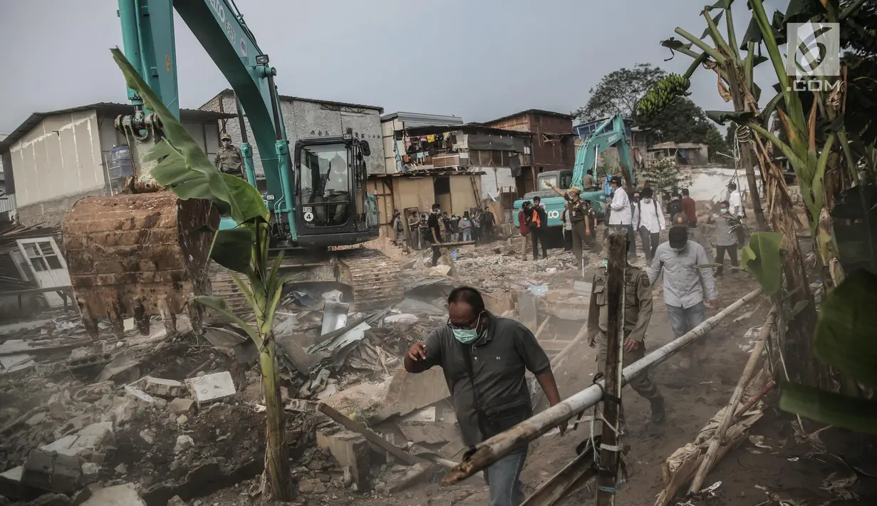 Sebuah alat berat digunakan untuk penertiban bangunan dikawasan bantaran Kali Ciliwung, Kelurahan Bukit Duri, Jakarta, Selasa (11/7). Sebanyak 345 bidang bangunan ditertibkan hari ini dengan target 333 kepala keluarga (KK). (Liputan6.com/Faizal Fanani)