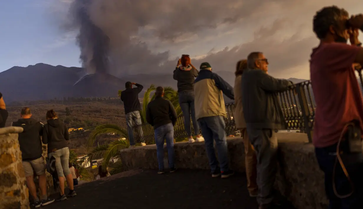 Wisatawan dan penduduk melihat dan mengambil foto gunung berapi yang meletus di Canary, Pulau La Palma, Spanyol, 26 Oktober 2021. Para pejabat mengatakan gunung berapi yang meletus selama lima minggu terakhir di Pulau La Palma lebih aktif dari sebelumnya. (AP Photo/Emilio Morenatti)