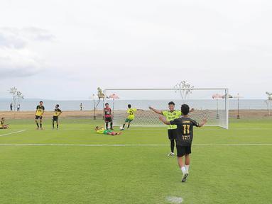 Sejumlah pesepak bola cilik bermain bola di Training Ground Bali United, Gianyar, Senin (28.03/2022). Mereka tampak senang menjajal lapangan latihan Bali United yang berada di pinggir pantai. (Bola.com/ M Iqbal Ichsan)