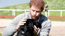 Ini saat Pangeran Harry main bersama seekor anjing. Mukanya menggemaskan banget! (Chris Jackson - WPA Pool/Getty Images/USWeekly)