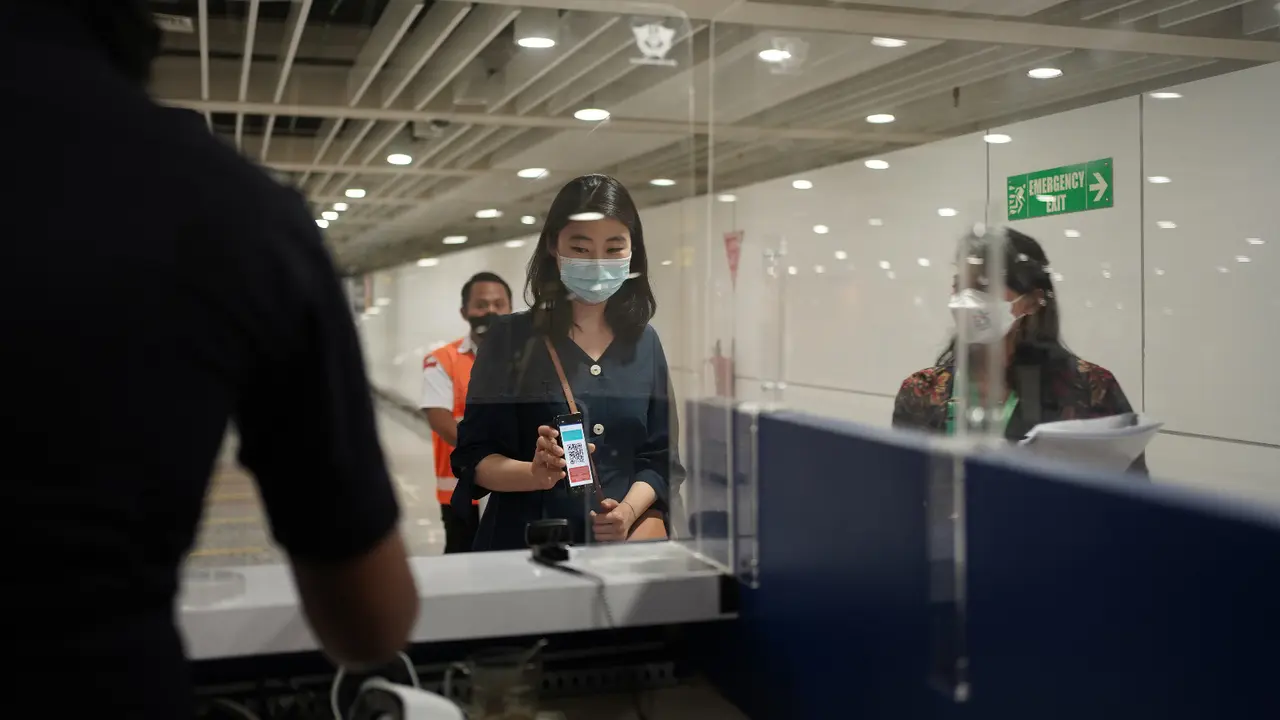 Salah seorang penumpang pesawat menunjukkan QR-Code kepada petugas Bea Cukai saat di area kedatangan bandara. (Istimewa)