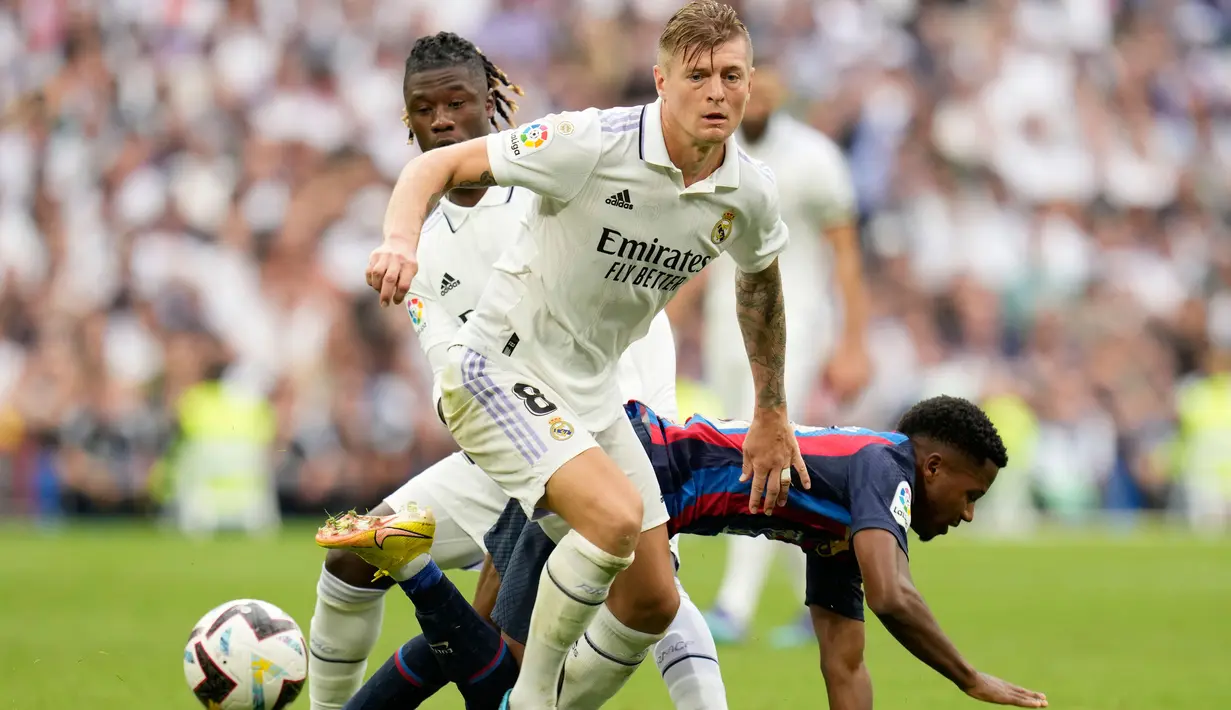 Pemain Barcelona Ansu Fati (kanan) berebut bola dengan pemain Real Madrid, Toni Kroos saat pertandingan sepak bola La Liga Spanyol di Stadion Santiago Bernabeu, Madrid, Minggu (16/10/2022). Pada pertandingan ini kedua tim saling berbalas serangan sejak awal permainan. Namun, usai 10 menit babak pertama Real Madrid tampil lebih menekan. (AP Photo/Manu Fernandez)