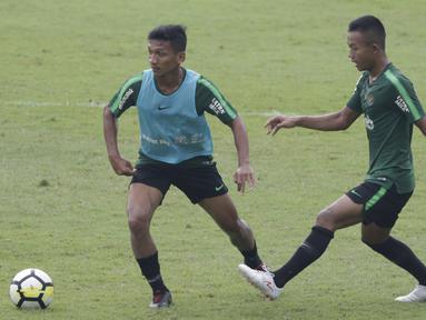Pemain Timnas Indonesia U-23, T. M. Ichsan, berebut bola dengan Sani Rizki, saat latihan di Stadion Madya, Jakarta, Rabu (13/3). Latihan ini merupakan persiapan jelang Kualifikasi Piala AFC U-23. (Bola.com/Vitalis Yogi Trisna)
