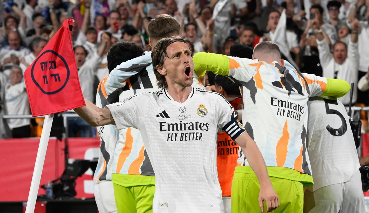 Capaian tersebut membuat Luka Modric menjadi pemain tersukses dalam sejarah Real Madrid. Tampak dalam foto, gelandang Real Madrid asal Kroasia, Luka Modric dan rekan setimnya merayakan gol kedua yang dicetak Aurelien Tchouameni saat pertandingan final Piala Spanyol melawan FC Barcelona di stadion La Cartuja, Sevilla, pada tanggal 26 April 2025. (Josep LAGO/AFP)