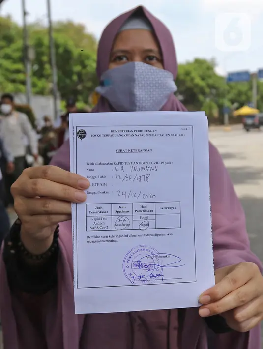 Warga menujukkan hasil Rapid Test Antigen di Rest Area KM 57, Tol Jakarta-Cikampek, Karawang, Jawa Barat, Kamis (24/12/2020). Rapid test antigen tersebut dilakukan untuk meminimalisir lonjakan kasus positif Covid-19 disaat libur Natal dan Tahun Baru 2020. (Liputan6.com/Herman Zakharia)