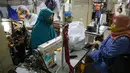 Penjahit melayani pelanggan di Pasar Mayestik, Jakarta, Selasa (11/5/2021). Menjelang Lebaran, pesanan jahitan turun sebesar 50 persen akibat pandemi COVID-19 serta larangan pemerintah terkait mudik luar kota dan mudik lokal. (Liputan6.com/Faizal Fanani)