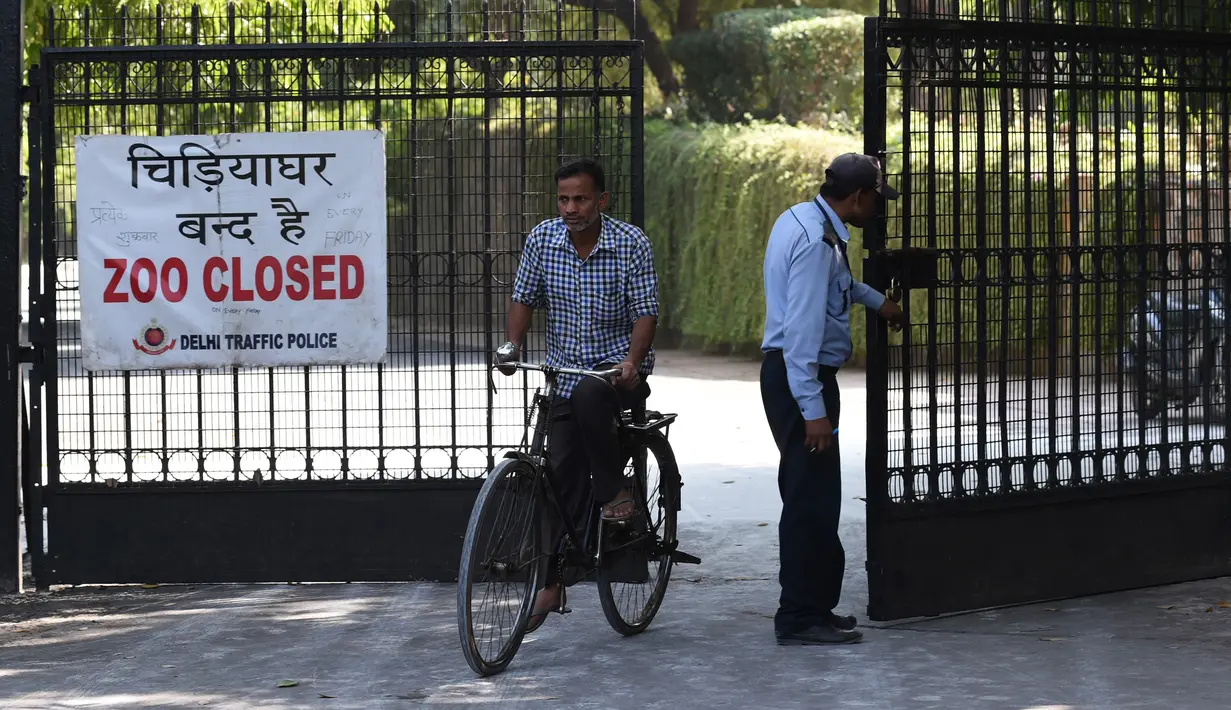 Pekerja masuk ke dalam Kebun Binatang Delhi yang tutup sementara di New Delhi, India, Rabu (19/10). Kebun binatang ditutup karena wabah flu burung yang menyerang hewan di kebun binatang tersebut. (AFP PHOTO / Sajjad Hussain)