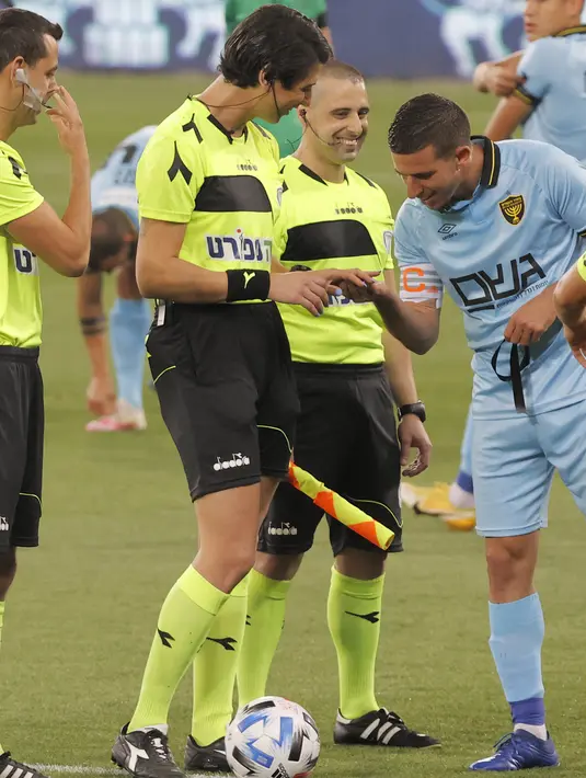 Kapten dan gelandang Beitar Jerusalem, Idan Vered (kanan) memeriksa jari-jari terawat wasit sepak bola transgender pertama Israel, Sapir Berman (tengah) sebelum Liga Premier Israel melawan Hapoel Haifa di Stadion Samy Ofer di kota Haifa, Senin (3/5/2021). (JACK GUEZ / AFP)