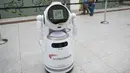 Para pengunjung berjalan melewati sebuah robot pintar yang menjelaskan tentang langkah-langkah pencegahan COVID-19 di sebuah pusat perbelanjaan di Frankfurt, Jerman, pada 12 September 2020. (Xinhua/Lu Yang)