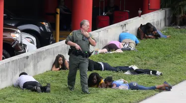 Sejumlah penumpang terbaring saat terjadi penembakan di Bandara Fort Lauderdale, Florida, AS (6/1). Peristiwa penembakan terjadi di tempat pengambilan bagasi bandara di Terminal 2. (Mike Stocker/South Florida Sun-Sentinel via AP)
