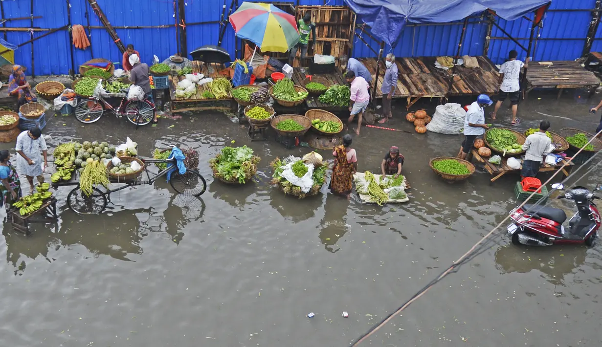 Pedagang sayur menunggu pelanggan di jalan yang terendam air setelah hujan lebat di Dhaka (21/7/2020). Korban tewas akibat hujan lebat di Asia Selatan meningkat menjadi hampir 200, ketika Bangladesh dan Nepal memperingatkan bahwa naiknya air akan membawa banjir lebih lanjut. (AFP/Munir Uz zaman)