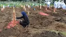 Seorang perempuan berdoa di salah satu makam khusus Covid-19 di TPU Tegal Alur, Jakarta, Kamis (17/12/2020). Hingga hari ini, intensitas pemakamanan korban covid-19 di DKI masih tinggi dengan rata-rata yang dimakamkan mencapai 30 hingga 38 jenazah per hari. (merdeka.com/Arie basuki)