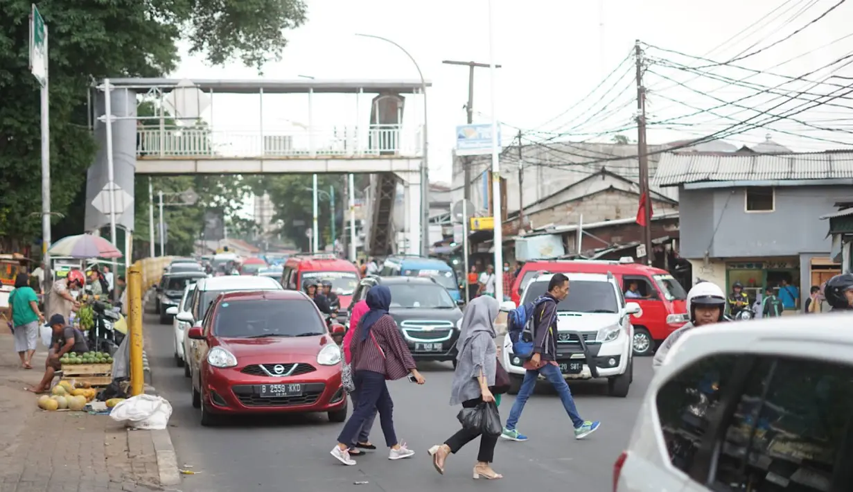 Pejalan kaki menyeberangi jalan di depan Stasiun Lenteng Agung, Jakarta, Senin (4/11/2019). Meski telah tersedia JPO, sebagian pejalan kaki lebih memilih untuk menyeberang sembarangan sehingga mengganggu arus lalu lintas serta berpotensi menimbulkan kecelakaan. (Liputan6.com/Immanuel Antonius)