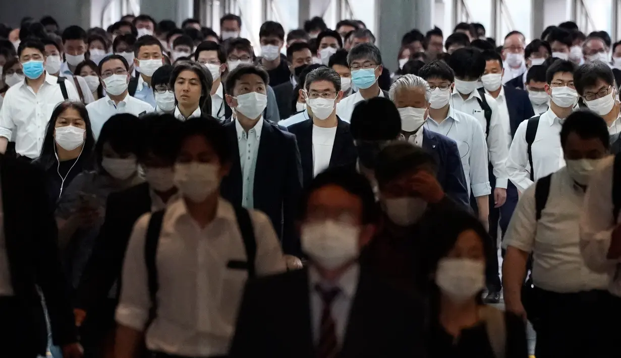 Sebuah lorong stasiun dipenuhi oleh para penumpang yang menggunakan masker selama jam sibuk di Tokyo, Selasa (26/5/2020). Perdana Menteri Jepang Shinzo Abe mencabut keadaan darurat pandemi virus corona di Tokyo dan empat wilayah lainnya pada Senin (25/5). (AP Photo/Eugene Hoshiko)