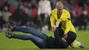 <p>Kiper Sevilla, Marko Dmitrovic berhasil melumpuhkan seorang suporter fanatik PSV yang menyerangnya dalam laga leg kedua babak playoff fase gugur Liga Europa 2022/2023 di Philips Stadium, Eindhoven, Jumat (24/2/2023). (AP Photo/Peter Dejong)</p>