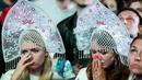 Dua orang suporter tampak kecewa usai Rusia kalah dari Kroasia pada laga perempat final Piala Dunia di Stadion Olimpiade Fisht, Sabtu (7/7/2018). Rusia kalah adu penalti dengan skor 3-4 dari Kroasia. (AFP/Olga Maltseva)