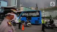 Petugas polisi mengimbau pengguna kendaraan saat melakukan Pengawasan Pelaksanaan PSBB di kawasan Bundaran HI, Jakarta, Senin (13/4/2020). Petugas juga mengimbau mengatur posisi duduk dan pembatasan penumpang untuk kendaraan bermobil baik pribadi maupun angkutan umum. (Liputan6.com/Faizal Fanani)