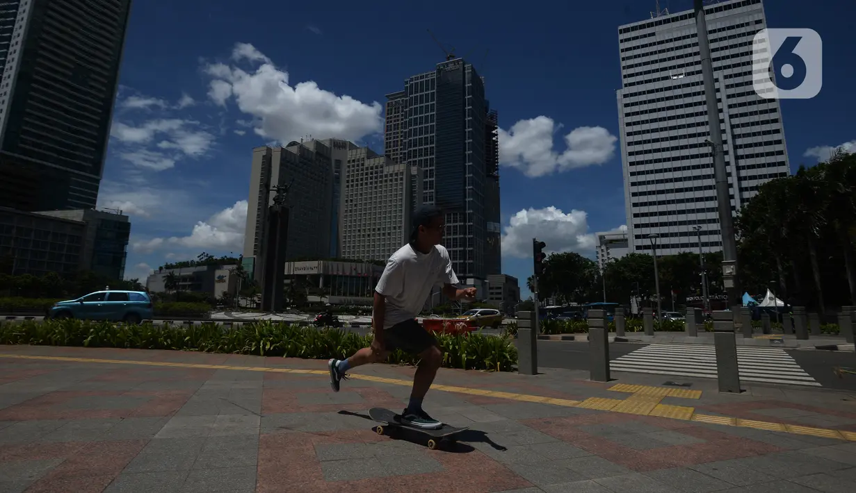 Pria main skateboard saat cuaca cerah di Jakarta, Selasa (1/12/2020). Kota Jakarta dengan langit biru menambah keindahan hutan beton. BMKG bahwa kualitas udara Jakarta jadi baik dalam dua minggu ini, Jakarta mengalami hujan dengan intensitas tinggi disertai angin kencang. (merdeka.com/Imam Buhori)
