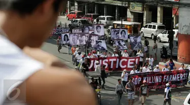 Demonstran menggelar aksi mengecam pembunuhan oleh Tentara Rakyat Baru, Manila, Filipina, Jumat (31/3). Mereka meminta Presiden Duterte untuk membicarakan perdamaian dengan pemberontak agar tidak membunuhi petani. (AP Photo / Aaron Favila)