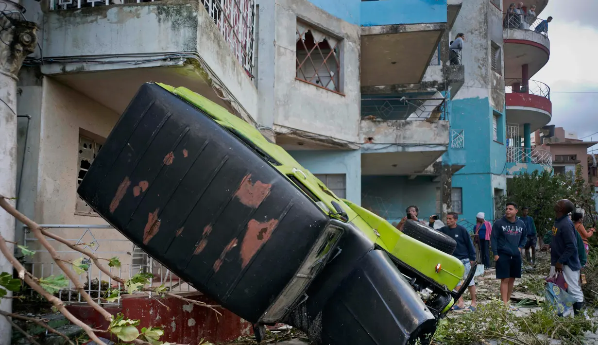 Sebuah mobil rusak setelah terlampar akibat badai tornado di Regla, Kuba (28/1). Akibat bencana tersebut tiga orang tewas dan 173 orang lainnya luka-luka. (AP Photo/Ramon Espinosa)
