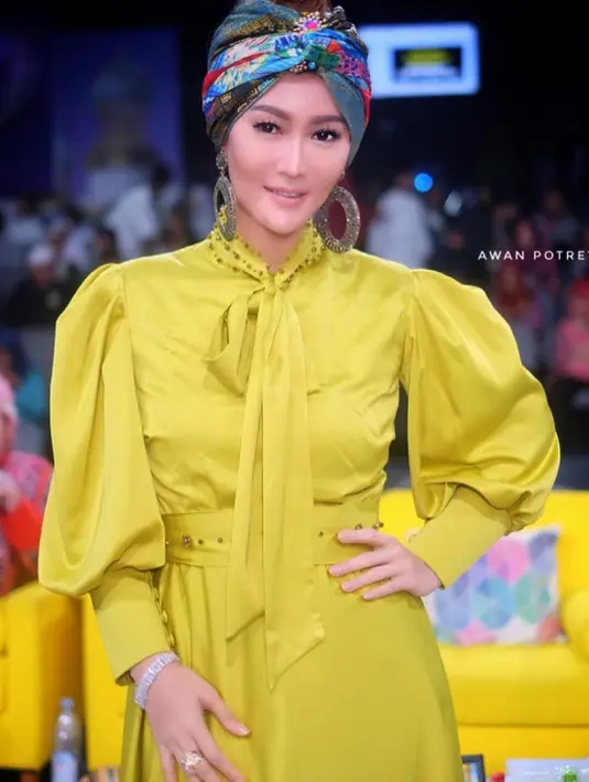 Senyum Inul Daratista terpancar dengan turban berwarna biru. Turban tersebut sangat cocok dikombinasikan dengan busana yang dipakai Inul berwarna kuning. (Liputan6.com/IG/@inul.d)