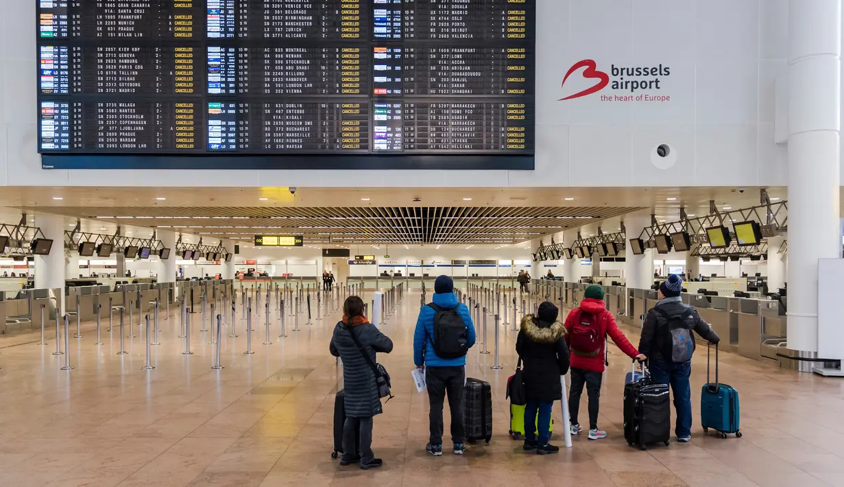 Penumpang melihat layar informasi keberangkatan di Bandara Brussels, Zaventem, Belgia, Rabu (13/2). Menurut badan lalu lintas udara Skeyes, wilayah udara Belgia ditutup selama 24 jam. (AP Photo/Geert Vanden Wijngaert)