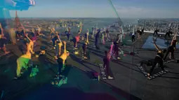 Praktisi yoga menghadiri kelas di Edge Observation Deck, Manhattan, New York, Amerika Serikat, Kamis (17/6/2021). Edge Observation Deck memiliki ketinggian 1.131 kaki (345 meter). (Ed JONES/AFP)