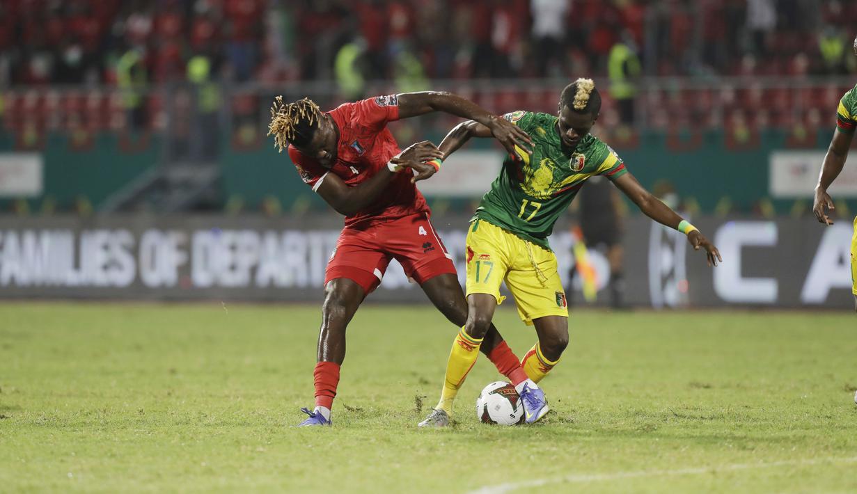 Bek Mali, Falaye Sacko berebut bola dengan gelandang Guinea Khatulistiwa, Federico Nchama pada babak 16 besar Piala Afrika 2021 di Stadion Limbe, Kamis (27/1/2022) dini hari WIB. Guinea Ekuatorial mempermalukan Timnas Mali 6-5 (0-0) dalam adu penalti. (AP Photo/Sunday Alamba)