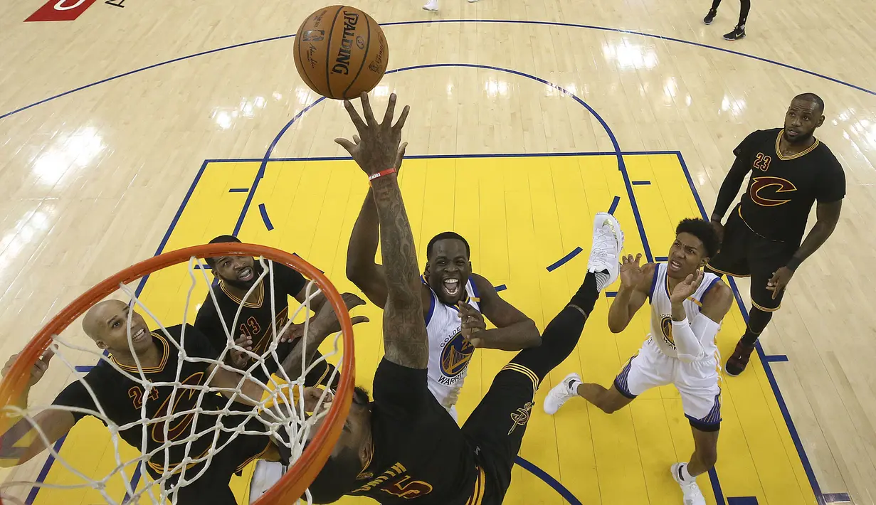 Pemain Golden State Warriors, Draymond Green berusaha memasukan bola kedalam keranjang melewati adangan pemain Cleveland Cavaliers pada final NBA di Oracle Arena, Oakland (12/6/2017).  (Ezra Shaw/Pool Photo via AP)
