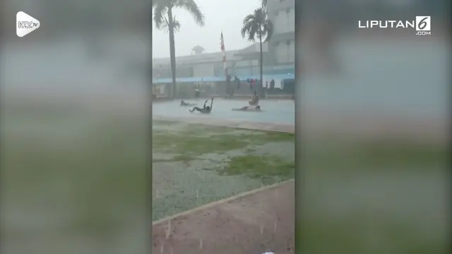 Seorang warga merekam momen unik saat para narapidana LP Cipinang bermain hujan-hujanan di lapangan basket.
