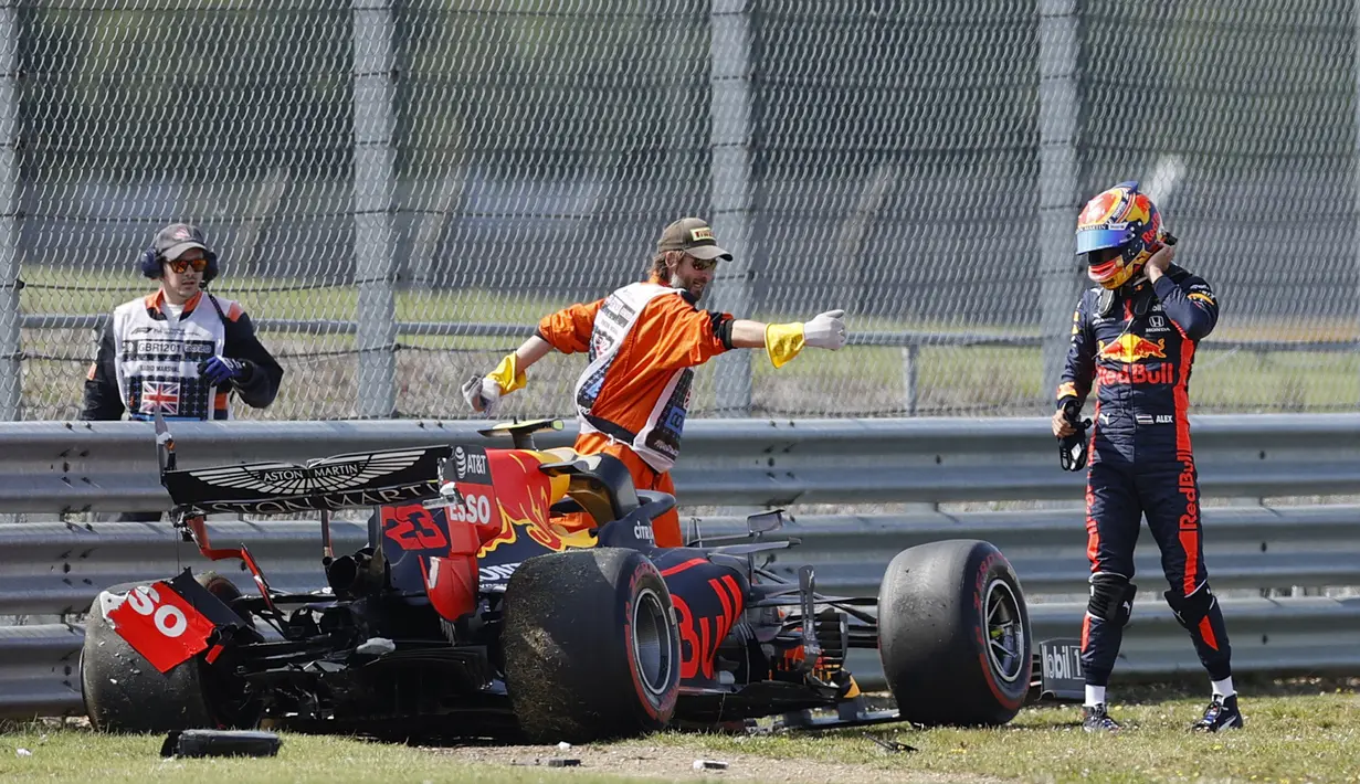 Pembalap Red Bull, Alex Albon, keluar dari mobil usai menabrak pembatas dalam sesi latihan kedua F1 Grand Prix Inggris di sirkuit Silverstone, Inggris, Sabtu (1/8/2020). Albon menempati urutan kedua dengan catatan waktu satu menit 27,364 detik. (AFP/Andrew Boyers/pool)