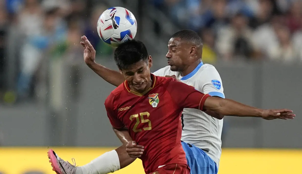 Pemain Uruguay, Nicolas De La Cruz (kanan) berduel udara dengan pemain Bolivia, Yomar Rocha pada laga Grup C Copa America 2024 di MetLife Stadium, East Rutherford, New Jersey, Jumat (28/06/2024) WIB. (AP Photo/Julia Nikhinson)